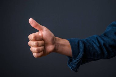 Parmak kaldıran bir elin yakın çekimi. İyi olma kavramı, her şey yolunda.