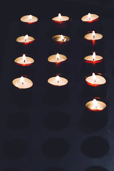 Eine Vertikale Aufnahme Kleiner Brennender Kerzen Dunkeln — Stockfoto
