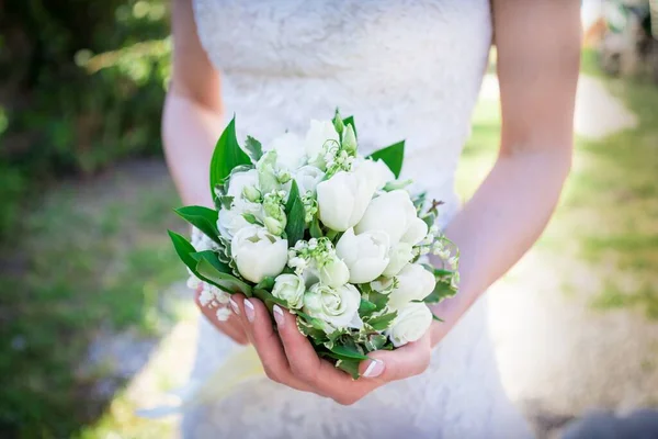 結婚式で彼女の手に美しい白いチューリップの花束を持っている花嫁のクローズ — ストック写真