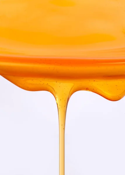 Een Verticale Close Van Honing Druipt Een Witte Achtergrond — Stockfoto