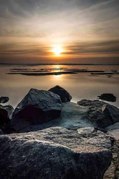岩の多い海に沈む夕日の美しいショット — ストック写真