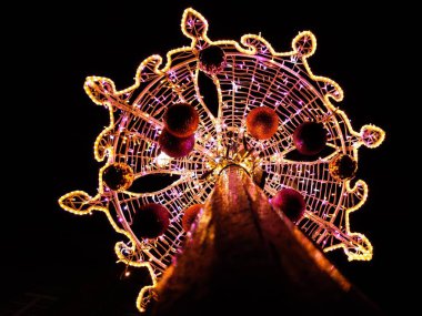 Noel için toplarla süslenmiş ışıklı bir lambanın düşük açılı çekimi.