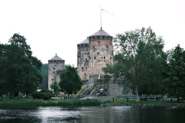 Finlandiya, Savonlinna 'da bir gölün kıyısındaki Olavinlinna ortaçağ kalesinin manzarası