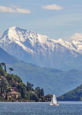 Gölde bir yelkenli, İsviçre 'nin arka planında güzel dağlar var.