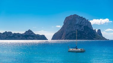 Ibiza, Cala dhort plaj, bir yelkenli ve kayalar denizin güzel güneşli deniz manzarası
