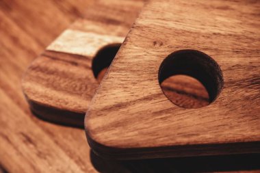 Asılacak deliklerle ahşap tahta kesen iki yakın çekim.