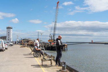 Kuzey Shields, İngiltere 'deki Fish Quay açıklarında Tyne Nehri' nde balık tutan insanlar var..