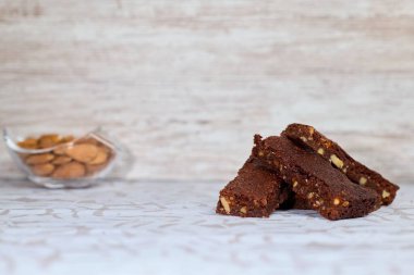 Arka planda bir kase bademli ve fındıklı browni resmi.