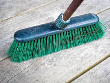 Arka bahçesi için sert yeşil plastik tüylü dış süpürge, tuğla kaldırım ve beton manzarası