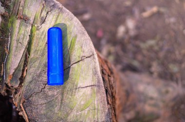 Bir kütüğün üzerindeki mavi plastik kapağın yakın çekimi..
