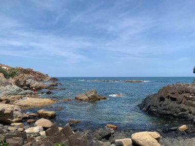 Sıcak bir yaz gününde, deniz kıyısının kayalık tarafı