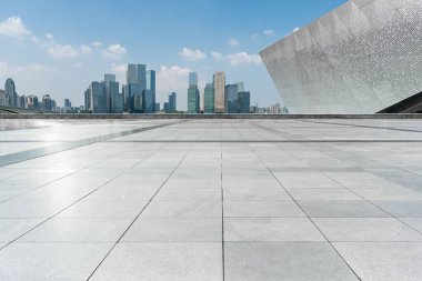 Arka planda şehrin silueti olan bir binanın çatısında boş bir tuğla zemin.