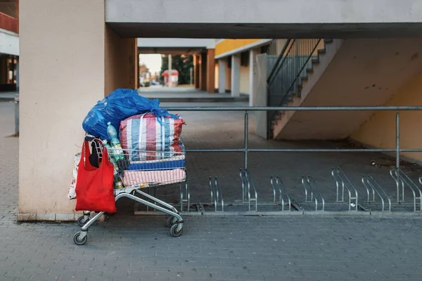 ホームレスの男性の所有物の運送人として使用される盗まれたショッピングカート 貧困の概念 — ストック写真