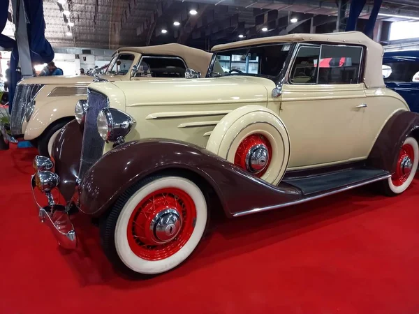 Eski model bej rengi kahverengi 1934 Chevrolet Chevrolet Master coupe cabriolet, kırmızı halıda GM tarafından. Klasik araba şovu.
