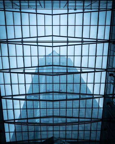 Вертикальный Снимок Отражения Современного Здания Через Стеклянный Потолок — стоковое фото