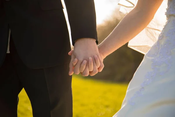 一对年轻夫妇在婚礼上牵着手的特写镜头 — 图库照片