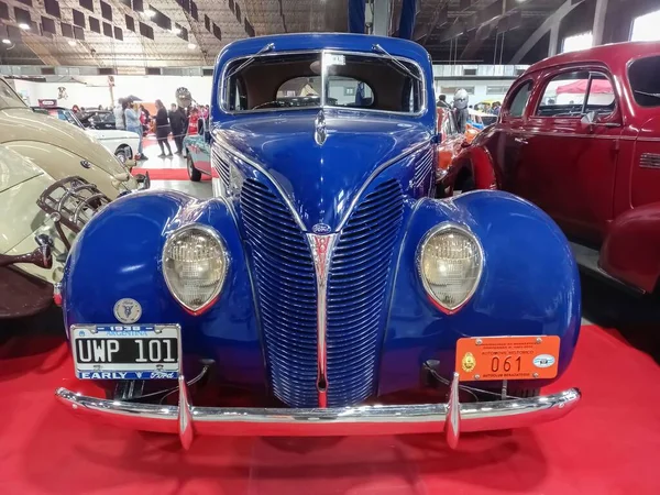 Eski model mavi 1938 Ford V8 85 De Luxe kırmızı halıda iki kapılı coupe. Ön manzara. Izgara. Sergi salonu. Klasik araba şovu..