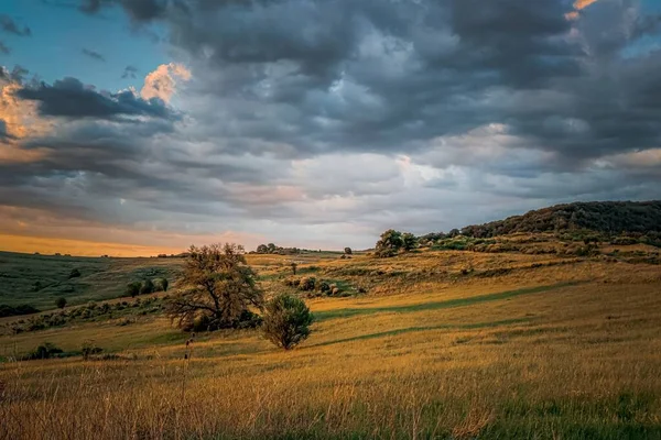 stock image A breathtaking sunset of a valley with dark clouds covering the orange sky