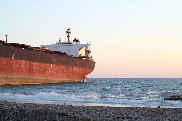 波涛汹涌的大海中的一艘货船 船尾有美丽的落日 — 图库照片