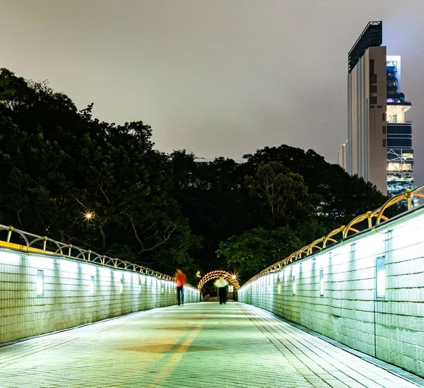 香港九龍の夜の道路上のライトアップされた歩道橋 — ストック写真