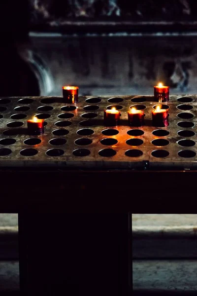 Eine Vertikale Aufnahme Brennender Kerzen Kerzenständern Einer Kirche Mit Verschwommenem — Stockfoto