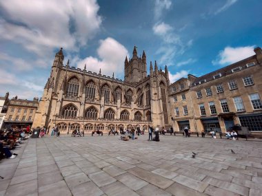 Bath, İngiltere 'deki Bath Manastırı' nı ziyaret eden turistler mavi bulutlu arka planda