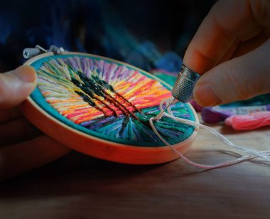 Çember ve iğneyle nakış işlerken yakın plan bir fotoğraf.