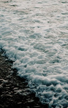Deniz dalgalarının köpüğünün dikey estetik görüntüsü