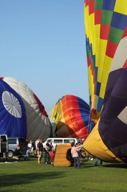Travers City 'deki sıcak hava balonu festivalinde balon şişiren insanların dikey görüntüsü.