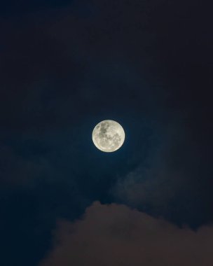 Gökyüzünde güzel bir dolunayın dikey görüntüsü.