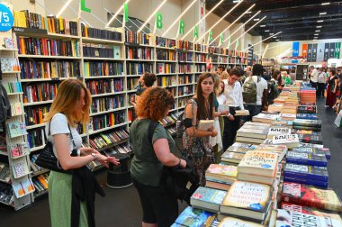 İkinci el kitapçıdaki raflardan kitap seçen gençlerin yakın çekimi.