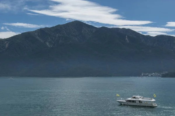 在晴朗的阴天 一艘白色的游艇在湖面上靠山漂浮着 — 图库照片