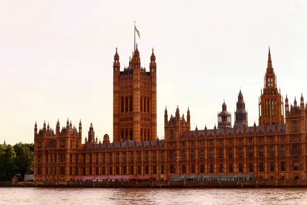 Красивый Снимок Вестминстерского Дворца Лондоне Водой Закатным Небом Заднем Плане — стоковое фото