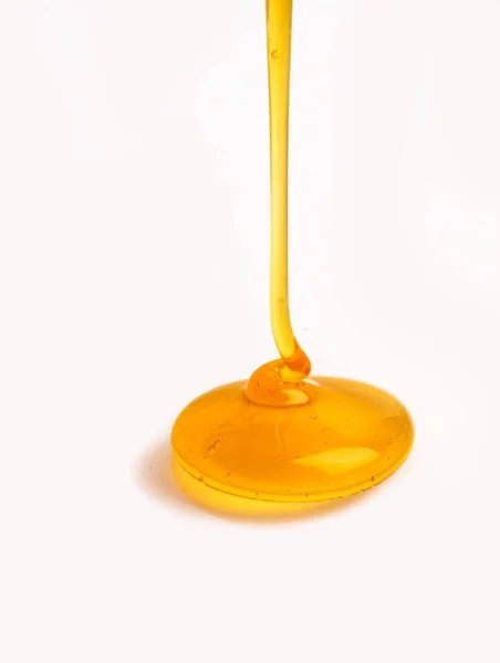 Een Verticale Close Van Honing Druipt Een Witte Achtergrond — Stockfoto