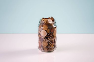 Masadaki cam kavanozda bir yığın bozuk para.