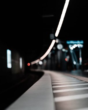 Alçak taban perspektifi bir yeraltı tren istasyonundaki bir platformun güvenlik alanına bakıyor