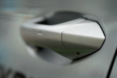 Gümüş bir arabanın kapı kolunun yakın çekimi.