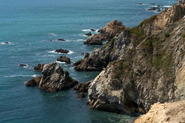 Kıyı şeridinin güzel bir manzarası. Tepe boyunca yayılan kayaları kaplayan dalgalar.