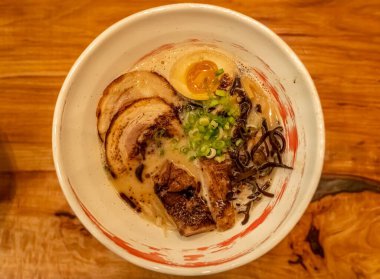 Ahşap masadaki kasede domuz etli ramen.