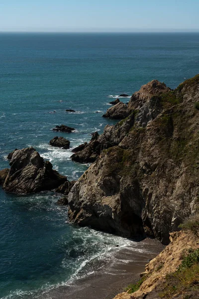 沿着山岗伸展出一条纵横的海岸线 波浪覆盖着岩石 — 图库照片