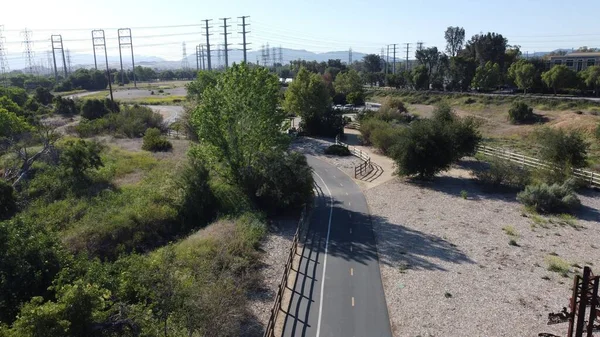 Yeşil ağaçlar boyunca uzanan bir otoyol manzarası.
