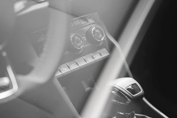 Acボタンやその他の制御ボタンとギアノブを備えた車の中のぼやけた景色 — ストック写真