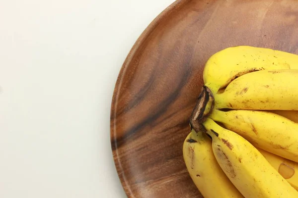 Primer Plano Racimo Plátanos Sobre Una Placa Marrón Aislada Sobre —  Fotos de Stock