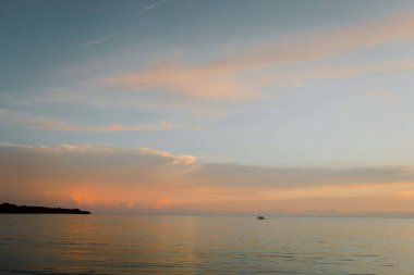 Denizin üzerindeki altın gün batımının büyüleyici görüntüsü