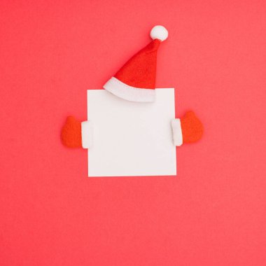 Bir Noel Baba kırmızı başlık ve kış eldivenleri. Pembe arka planda fotokopi alanı boş.