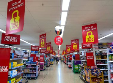 Sainsbury 'deki süpermarketin iç çekimleri yaşam krizi sırasında fiyat kilidi tabelalarını gösteriyor.