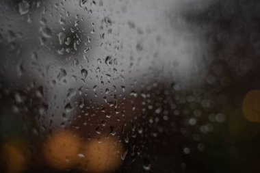 Yağmurlu bir günde ıslak bir pencereye su damlalarıyla yakın çekim