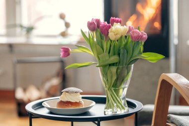 İsveç dilinde çiçek, laskiaispulla ya da fast-lagsbulle tabağının yanındaki semla şekerli rulonun yakın çekimi