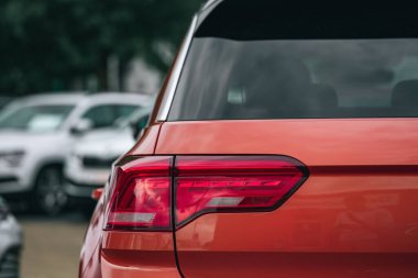 Bir otoparktaki mavi bir arabanın kırmızı stop lambasına yakın çekim.