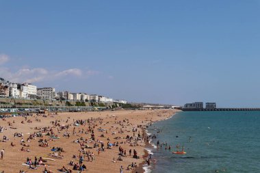 Brighton Sarayı yakınındaki sahilde eğlenen insanlar.